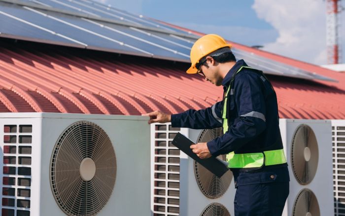Ingeniero revisa sistemas de aire acondicionado instalados la azotea.