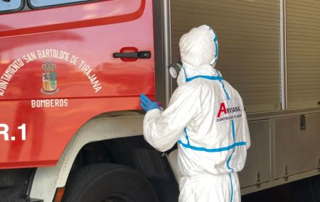 Técnico de Anviana con su traje EPI y un nebulizador esta desinfectado un camión de bomberos.