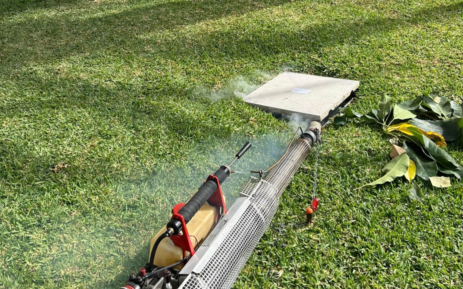 Gran pistola termo nebulizadora al borde de una alcantarilla en un jardín