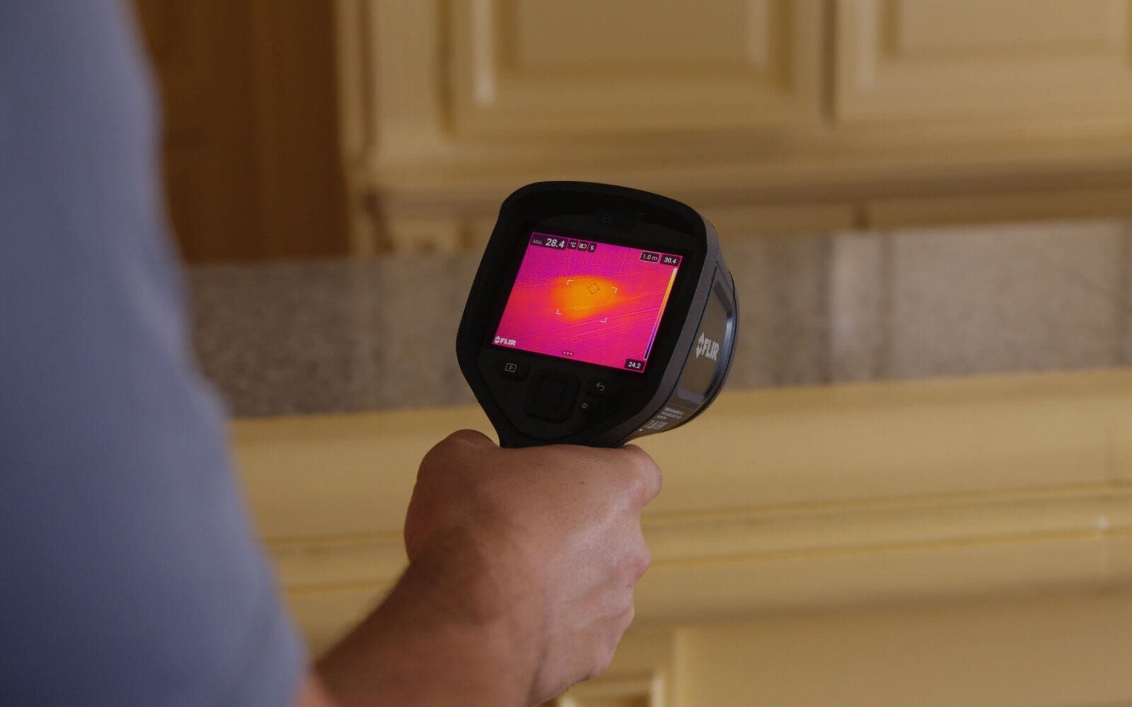 Operario de Anviana sujeta una pistola termográfica con la que analiza la pared.